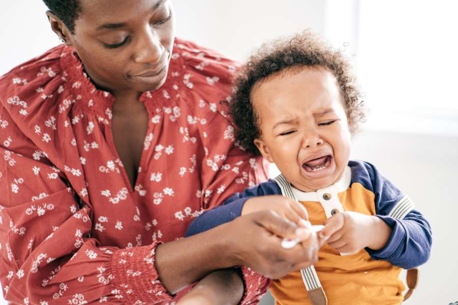 Une maman patiente tente de calmer son enfant en pleine crise de colère du terrible two.